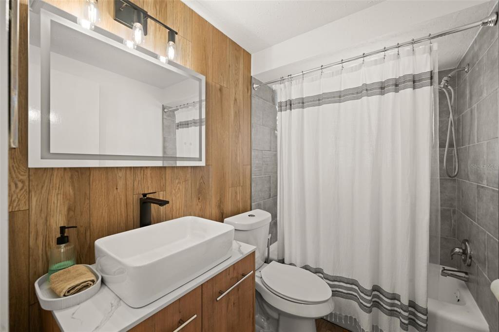 219 Coral Road Venice, FL 34293 - Photo 13 of 24 a bathroom with a sink a toilet a mirror and shower curtain