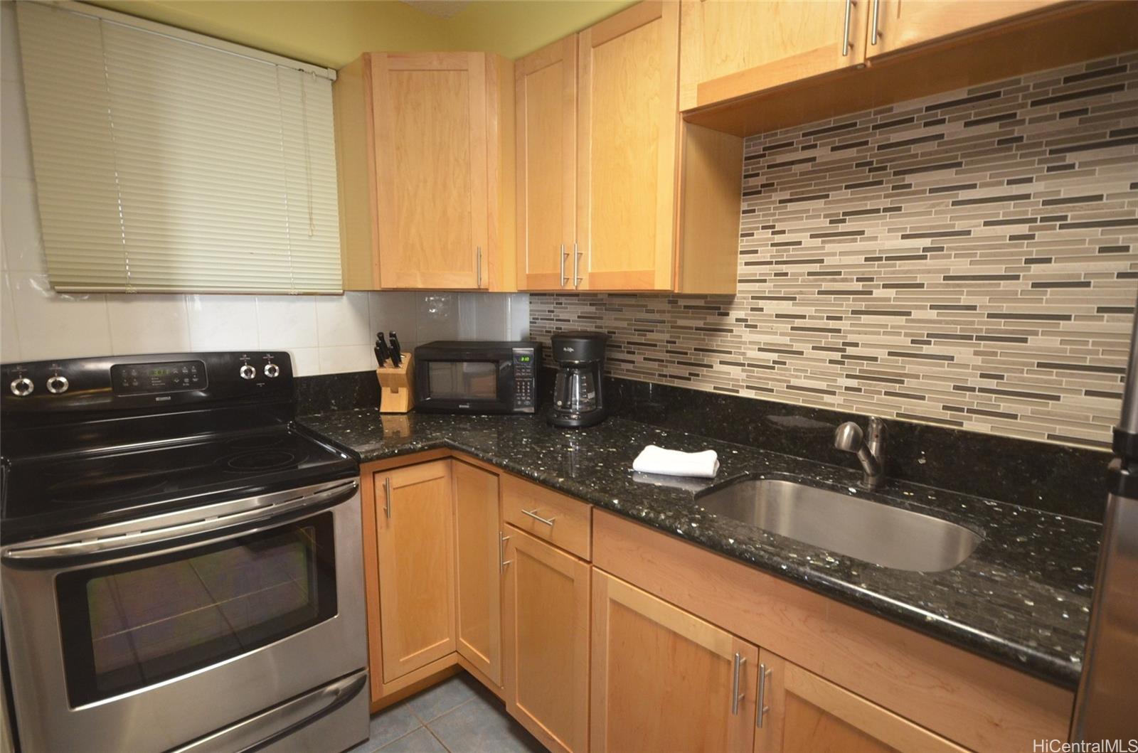a kitchen with granite countertop stainless steel appliances a sink dishwasher and cabinets