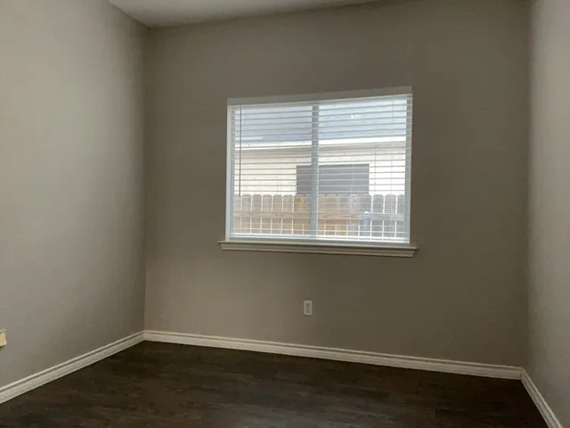 an empty room with wooden floor and closet area