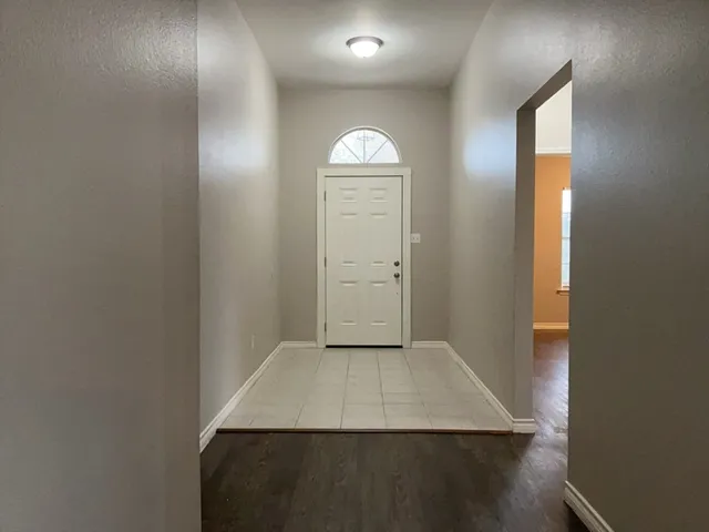 an empty room with wooden floor cabinet and closet