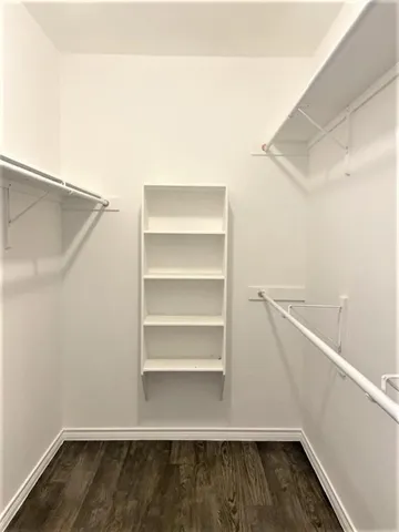 a view of walk in closet with empty racks
