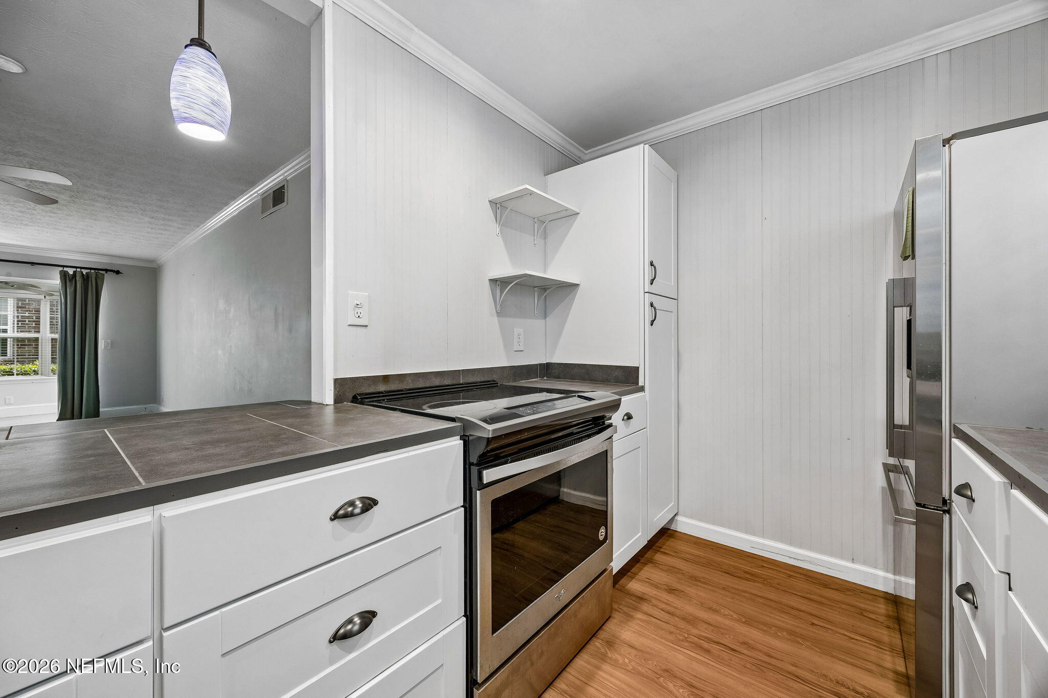 4358 Timuquana Road, Unit 134 Jacksonville, FL 32210 - Photo 7 of 31 a kitchen with granite countertop cabinets stainless steel appliances and wooden floor