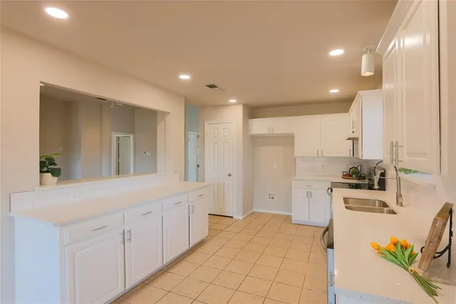 a view of a kitchen with kitchen island a sink stainless steel appliances and cabinets