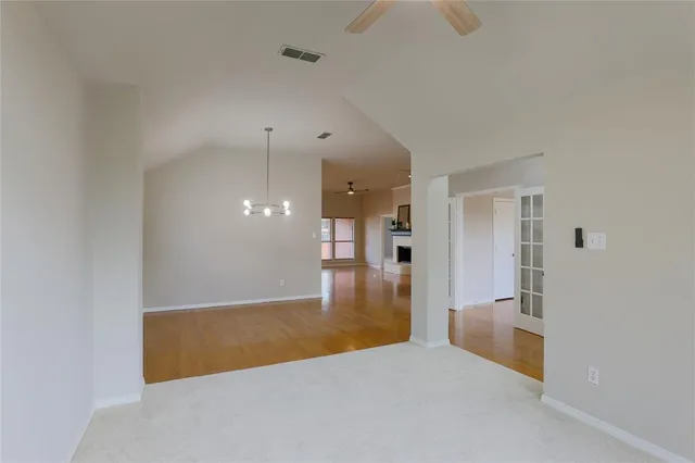 an empty room with a bathroom and mirror