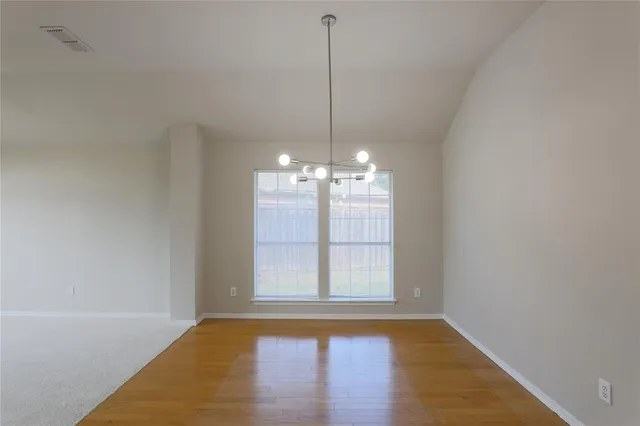 a view of a room with window wooden floor and chandelier