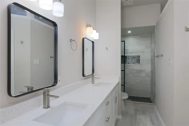 a bathroom with a sink a toilet and shower