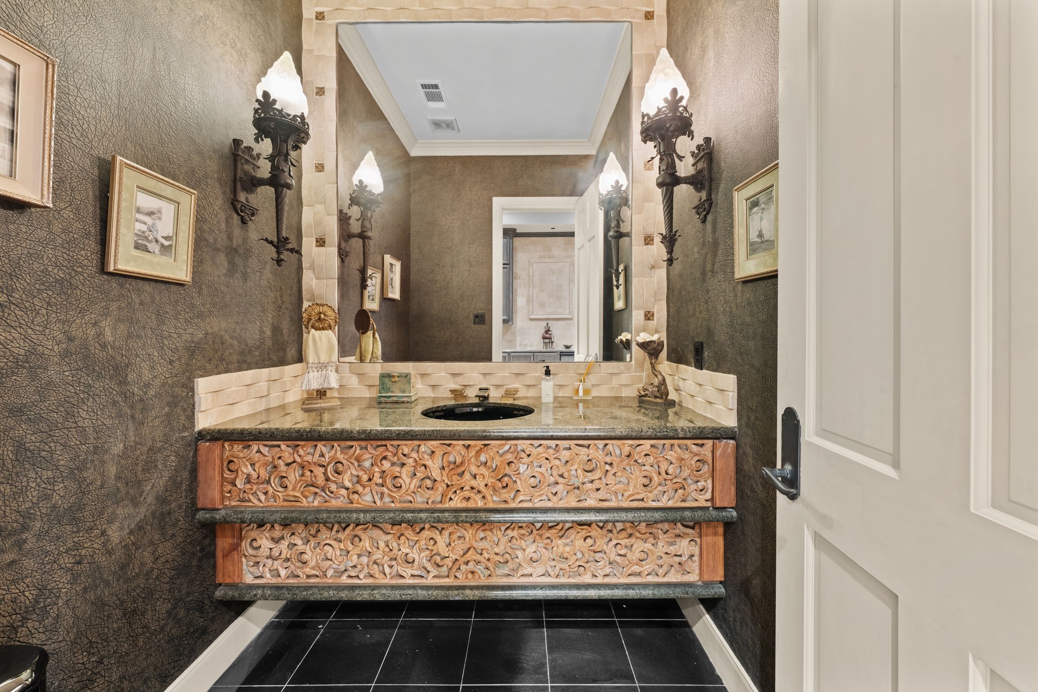 6 Mott Lane Houston, TX 77024 - Photo 37 of 50 Striking designer powder bath featuring rich textured walls, ornate custom vanity, and elegant sconces. A statement mirror and intricate detailing create a warm, sophisticated ambiance perfect for guests.