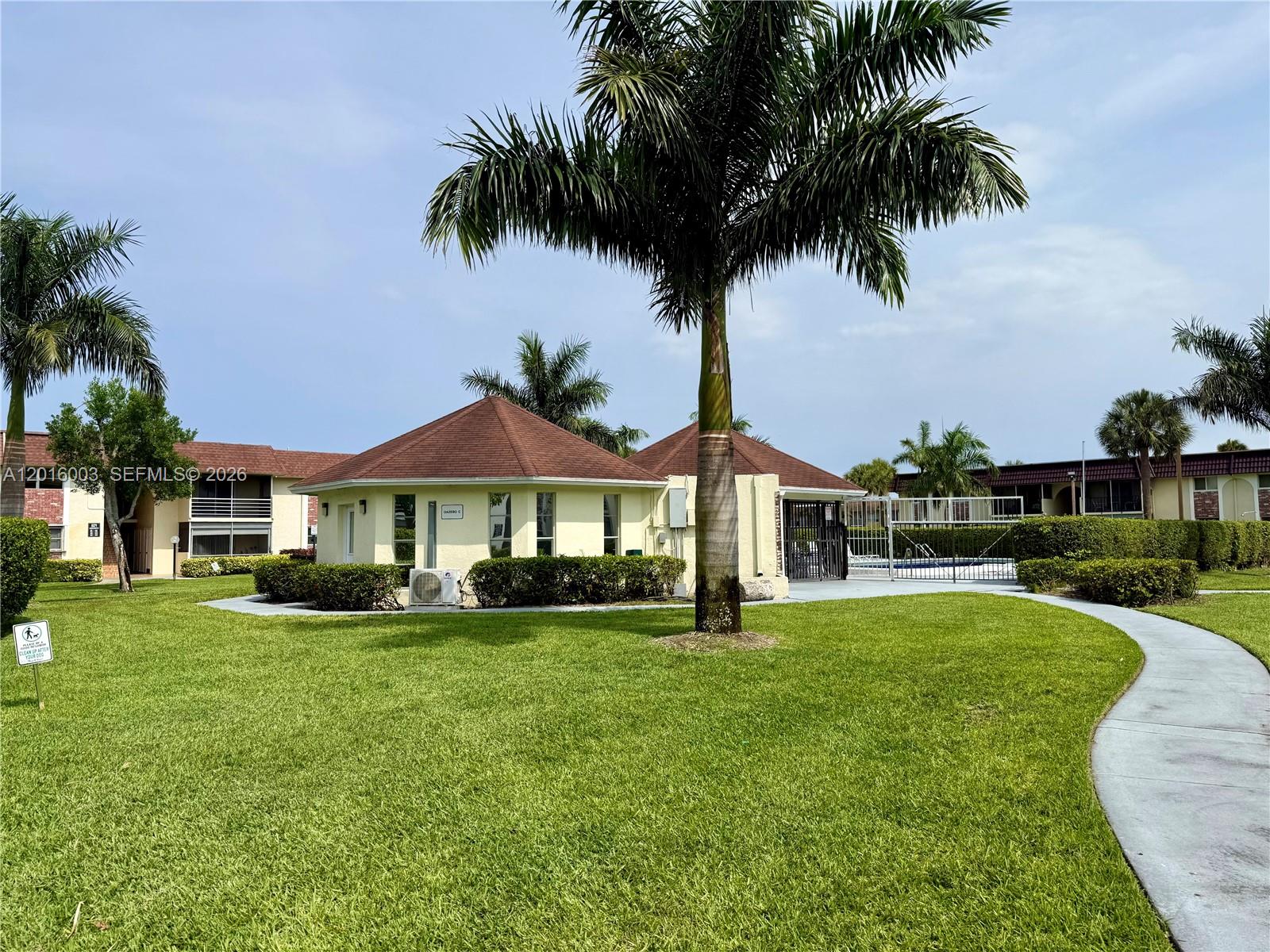 22805 Southwest 66th Avenue, Unit 208 Boca Raton, FL 33428 - Photo 1 of 28 a front view of a house with a yard and palm trees