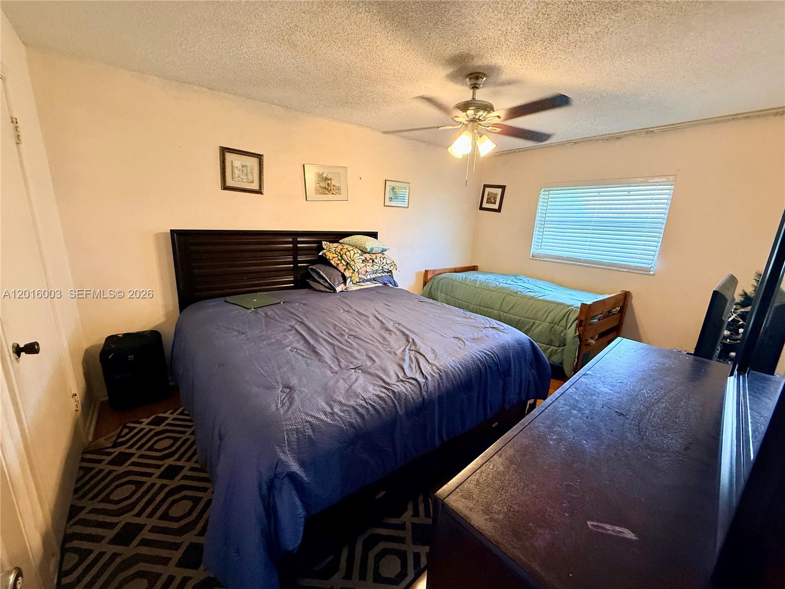 22805 Southwest 66th Avenue, Unit 208 Boca Raton, FL 33428 - Photo 21 of 28 a bedroom with two beds and a chandelier