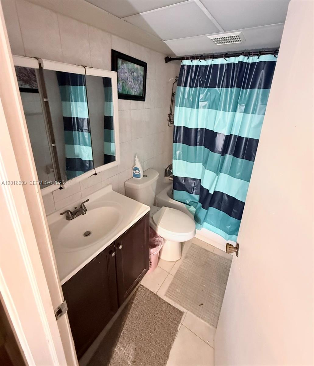 22805 Southwest 66th Avenue, Unit 208 Boca Raton, FL 33428 - Photo 25 of 28 a bathroom with a sink a toilet a shower curtain and sink