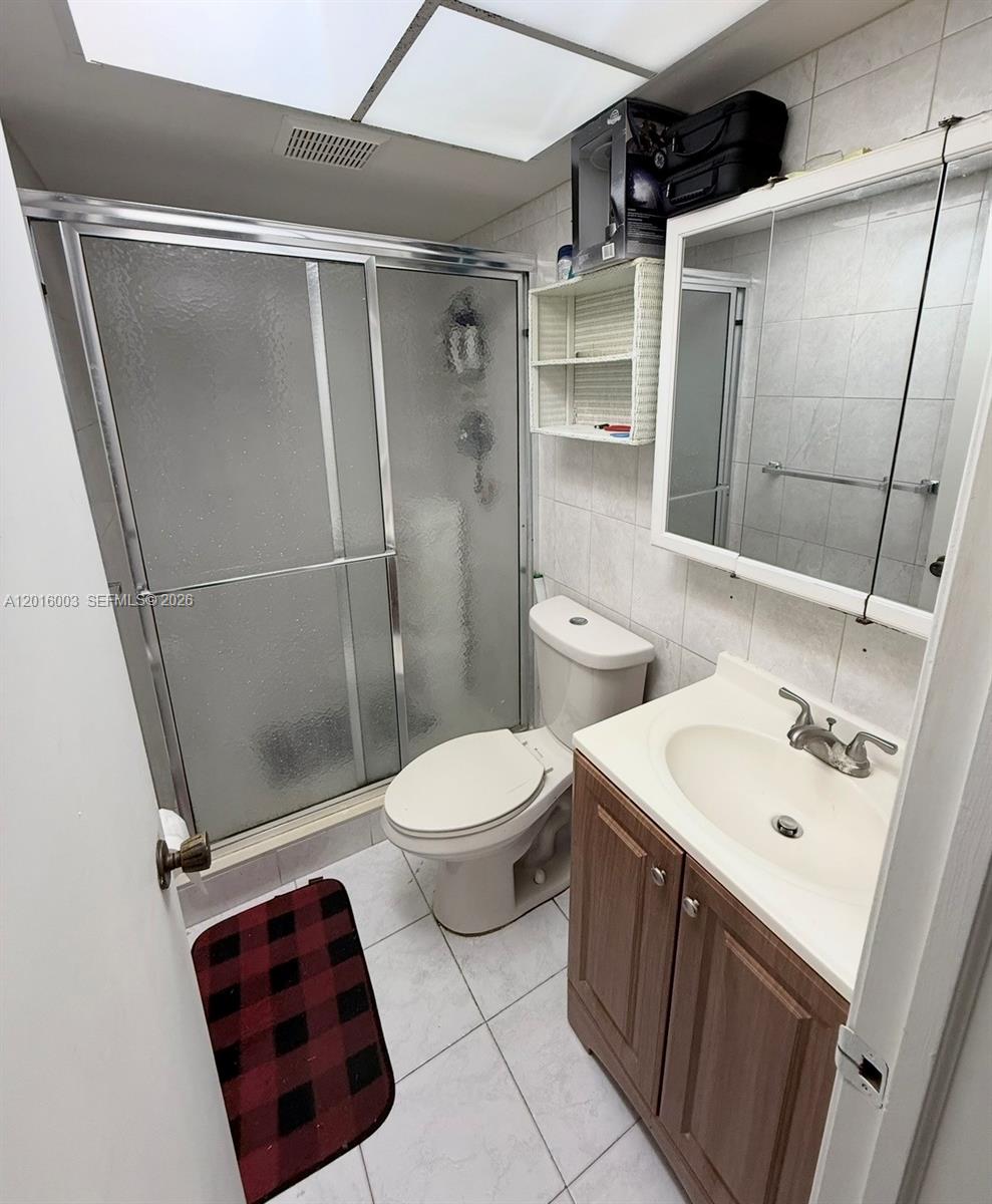 22805 Southwest 66th Avenue, Unit 208 Boca Raton, FL 33428 - Photo 26 of 28 a bathroom with a sink a toilet and shower