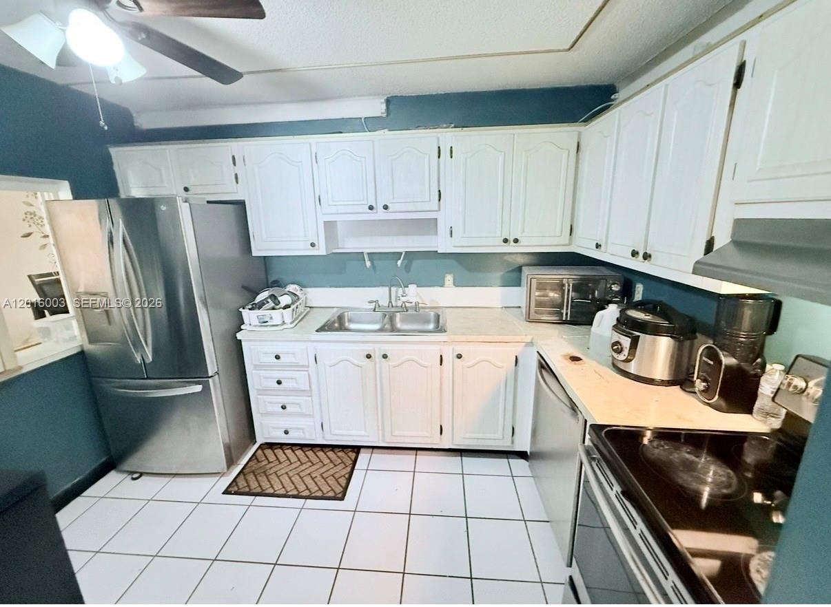 22805 Southwest 66th Avenue, Unit 208 Boca Raton, FL 33428 - Photo 27 of 28 a kitchen with white cabinets a stove and a refrigerator