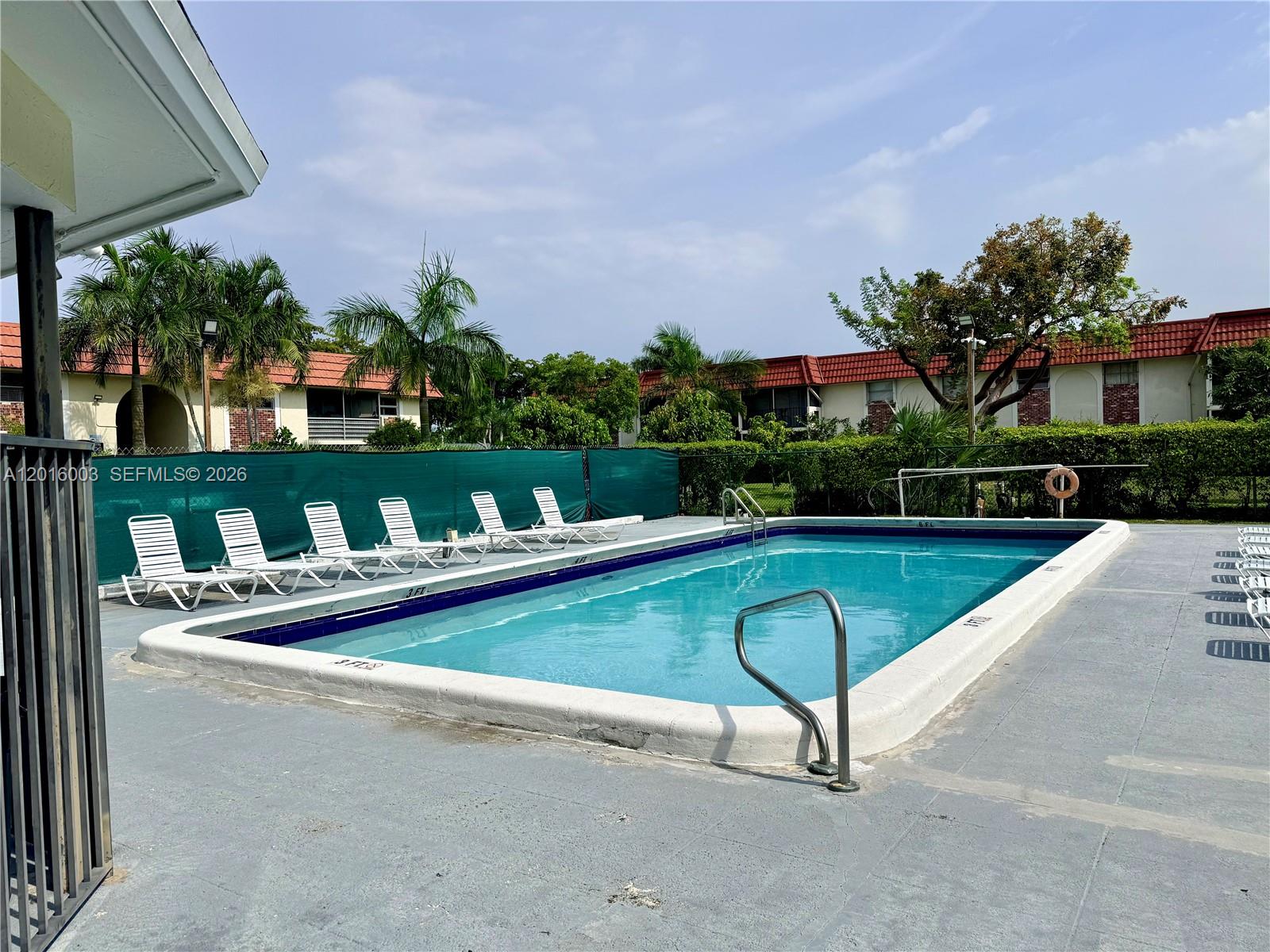 22805 Southwest 66th Avenue, Unit 208 Boca Raton, FL 33428 - Photo 8 of 28 a view of swimming pool with outdoor seating and trees in the background
