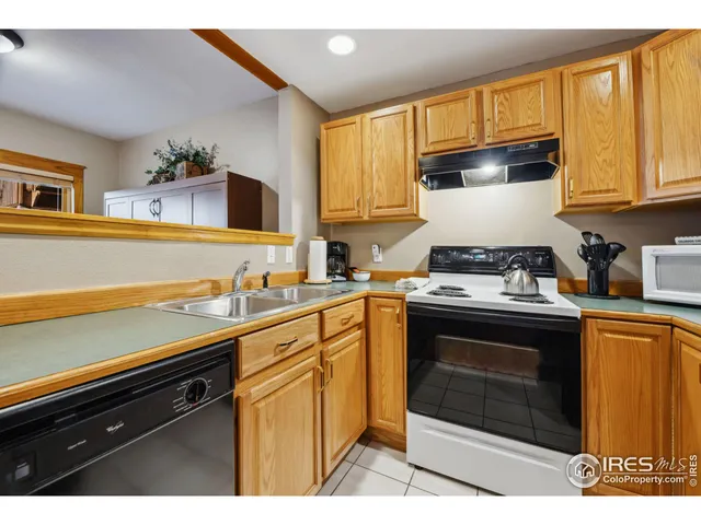 a kitchen with stainless steel appliances a stove a sink cabinets and a window
