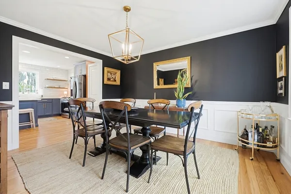 a view of a dining room with furniture a chandelier and wooden floor