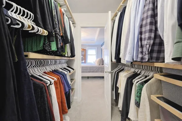 a view of walk in closet with clothes and shoes