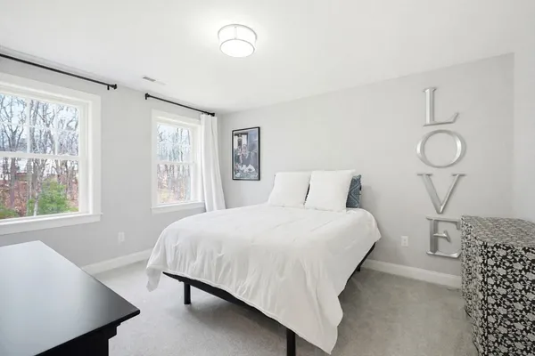 a bedroom with a bed and a window with balcony view