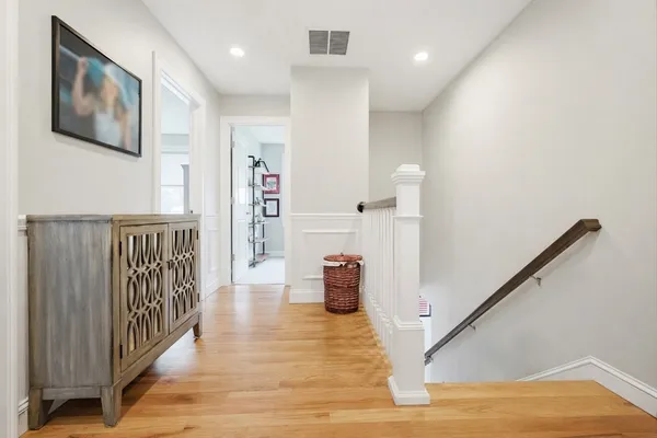 a view of a hallway with wooden floor and staircase