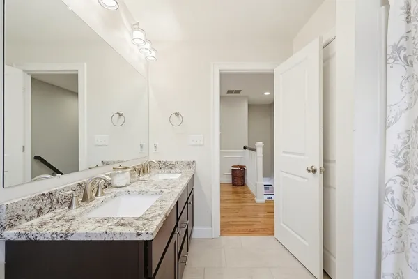 a en suite bathroom with a granite countertop sink and a mirror