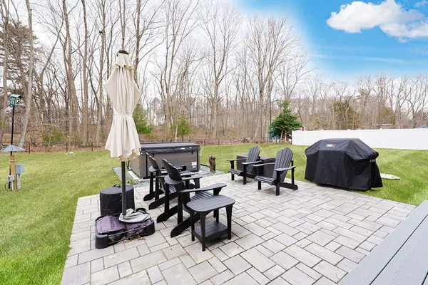 a view of a patio with table and chairs potted plants and a large tree