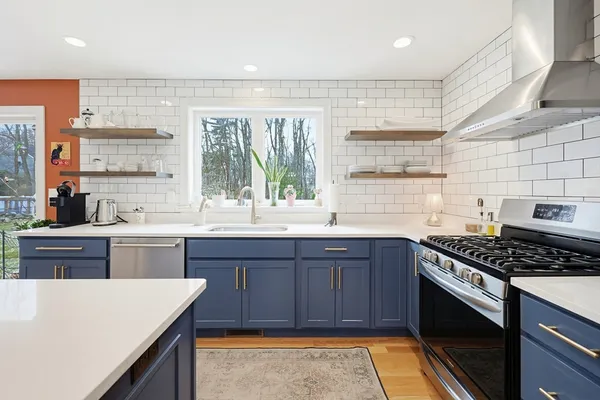 a kitchen with stainless steel appliances a stove a sink dishwasher and a refrigerator
