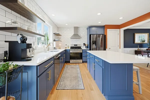 a large kitchen with stainless steel appliances kitchen island granite countertop a large counter top and wooden floors