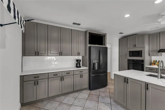 a kitchen with a sink a refrigerator and cabinets