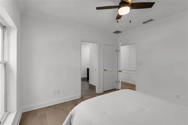 a bedroom with a bed and a chandelier fan