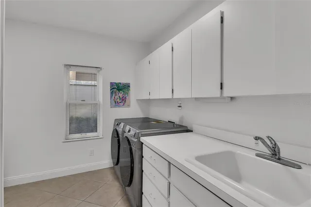 a view of a sink and dishwasher with white cabinets