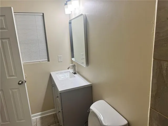 a bathroom with a toilet sink and mirror