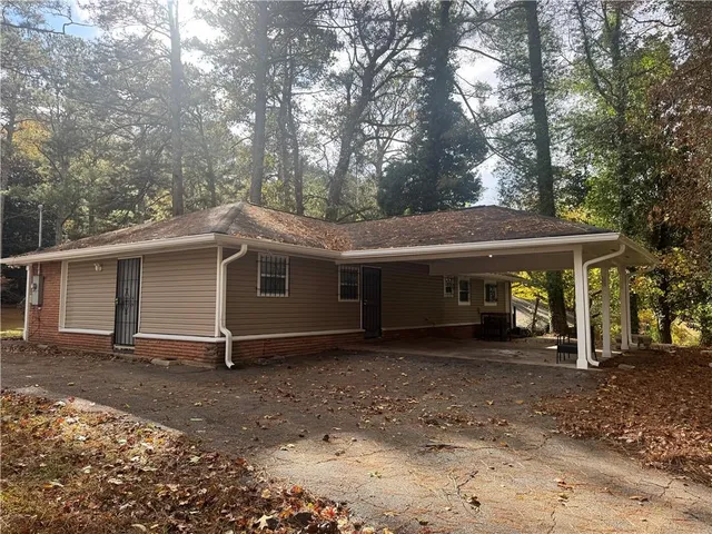a view of a house with a large tree and wooden fence