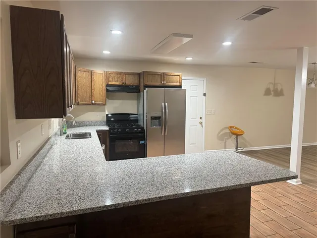 a kitchen with kitchen island a counter top space cabinets and stainless steel appliances