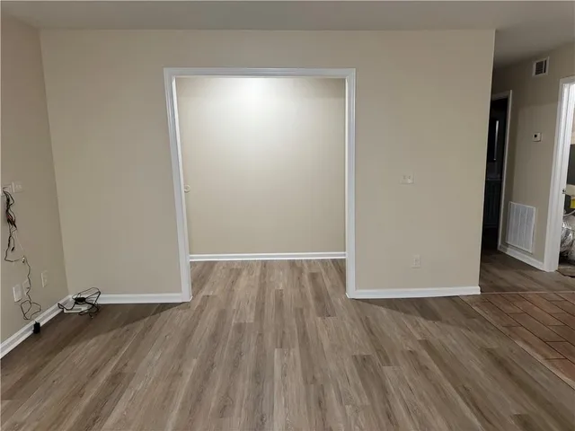 a view of a room with wooden floor and a window