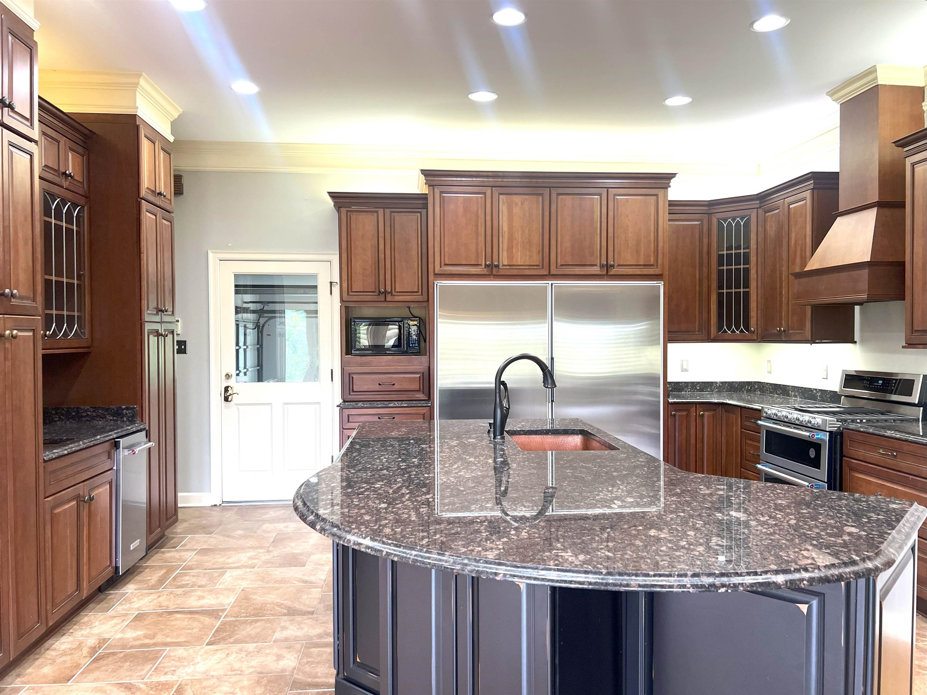 2055 Bobbitt Road Williston, TN 38076 - Photo 2 of 40 Kitchen featuring a sink, built in appliances, dark stone countertops, a center island with sink, and glass insert cabinets