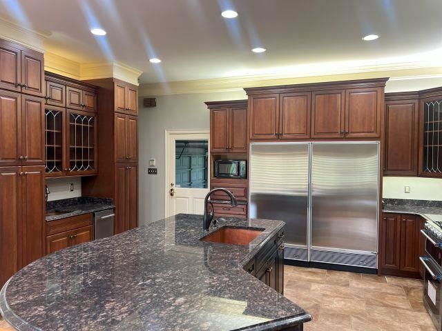 2055 Bobbitt Road Williston, TN 38076 - Photo 4 of 40 Kitchen featuring crown molding, a sink, built in appliances, a kitchen island with sink, and dark stone countertops