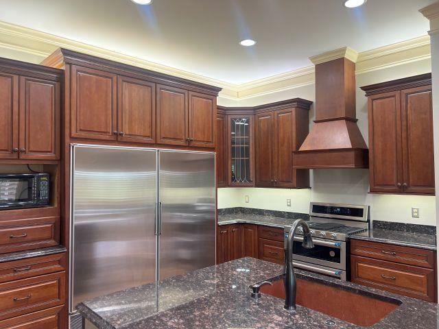 2055 Bobbitt Road Williston, TN 38076 - Photo 5 of 40 Kitchen with ornamental molding, custom exhaust hood, glass insert cabinets, dark stone countertops, and stainless steel appliances