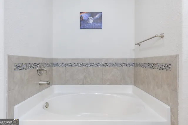 a white bath tub sitting next to a shower
