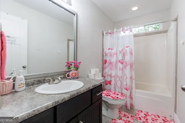 a bathroom with a granite countertop sink a toilet and a shower