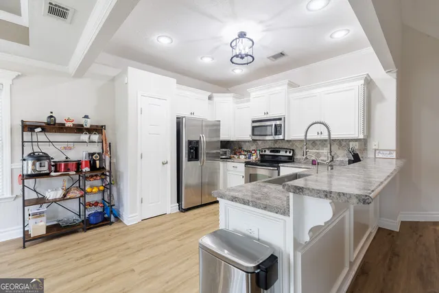 a kitchen with stainless steel appliances granite countertop a sink refrigerator and cabinets