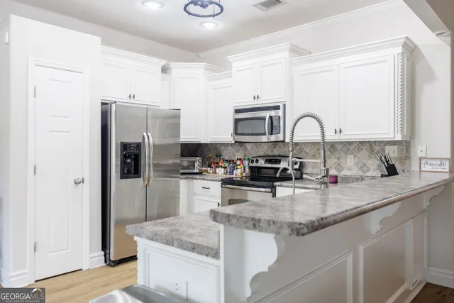 a kitchen with refrigerator and cabinets