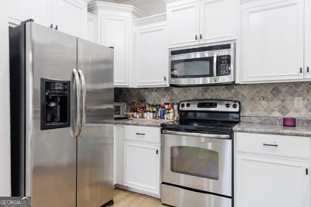 a kitchen with stainless steel appliances granite countertop a stove a refrigerator and a microwave