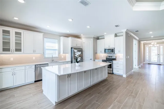 a kitchen with stainless steel appliances kitchen island granite countertop a stove and a sink