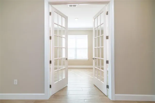 an empty room with wooden floor and windows