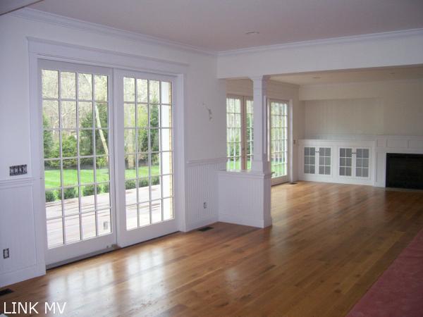 243 Katama Road Edgartown, MA 02539 - Photo 2 of 6 a view of an empty room with wooden floor and a window