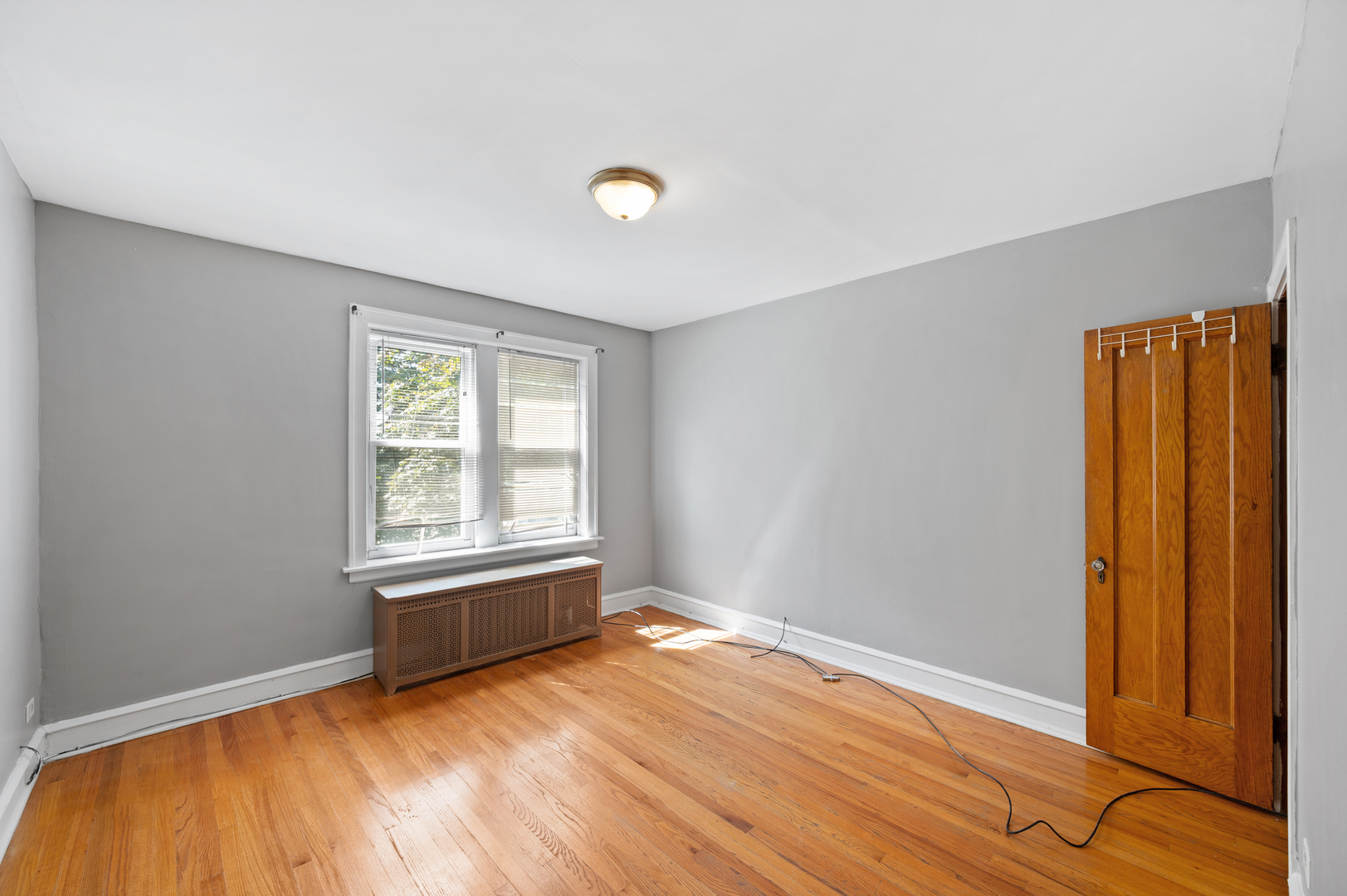 5256 West Wolfram Street, Unit 2 Chicago, IL 60641 - Photo 9 of 11 a view of an empty room with wooden floor and a window