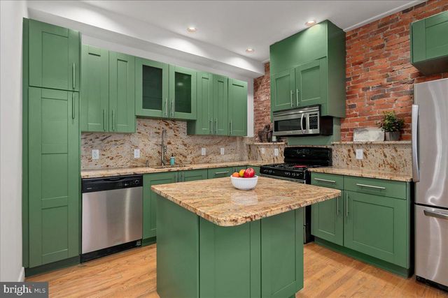 a kitchen with granite countertop a sink a stove and cabinets