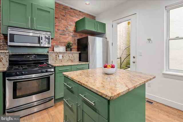 a bathroom with a sink a toilet a window and shower