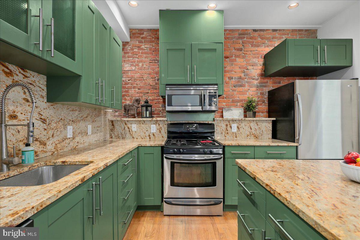 603 P Street Northwest Washington, DC 20001 - Photo 5 of 57 a kitchen with granite countertop a sink a stove and cabinets