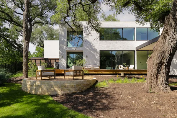 a front view of a house with garden and sitting area