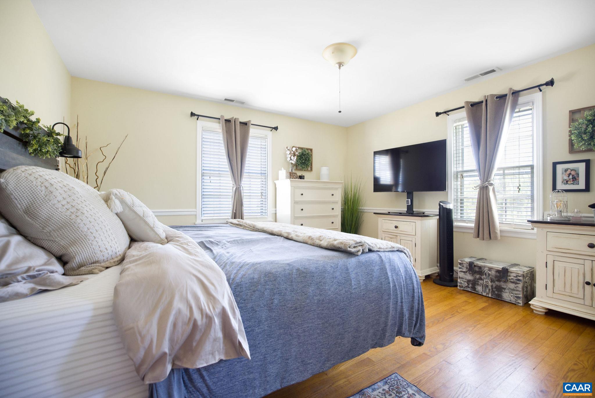 5374 Gordonsville Road Keswick, VA 22947 - Photo 16 of 35 a spacious bedroom with a bed and a flat tv screen on the dresser
